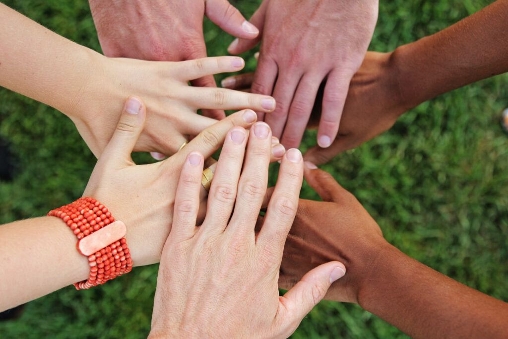 A upclose shot of seven hands put together showing a community together.